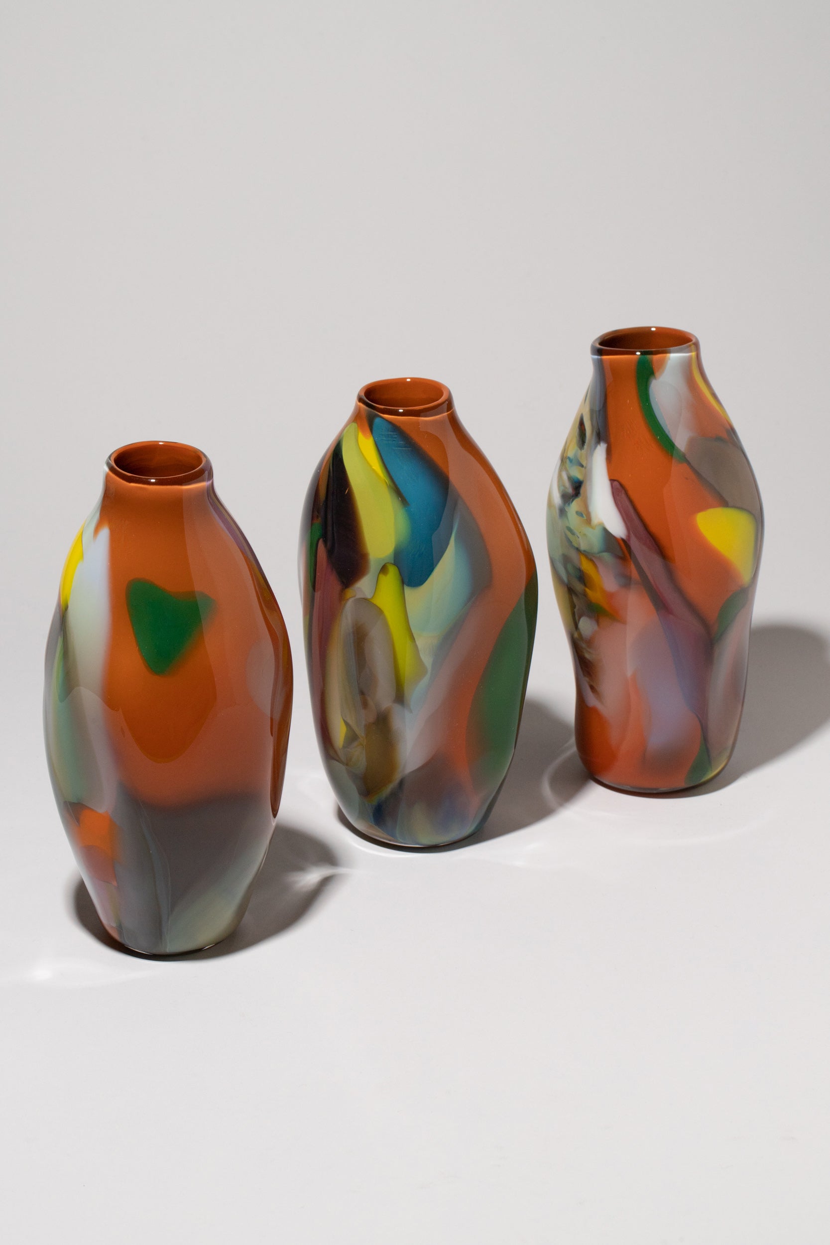 Group of BaleFire Glass Small Orange Epiphany Vases on light color background.