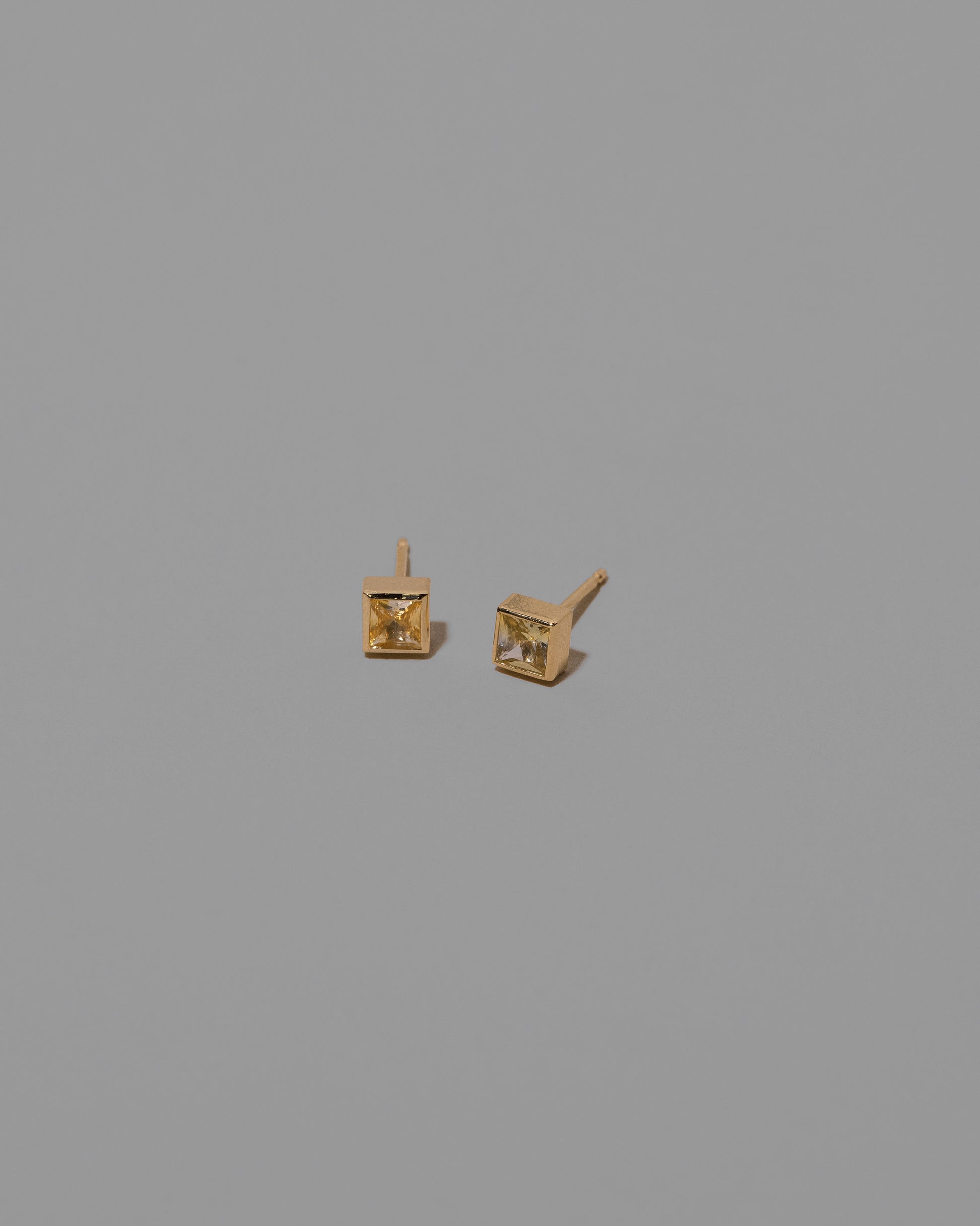 Bicolor Sapphire Square Frame Stud Earrings on light color background.