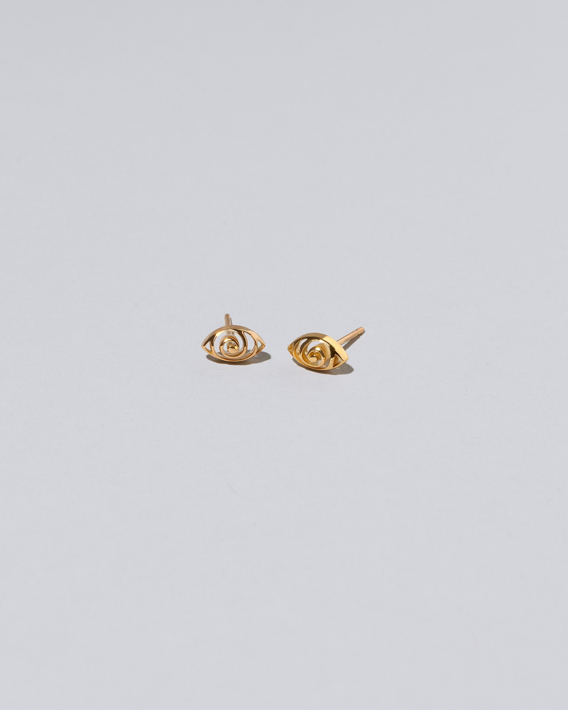 Gold Altered State Stud Earrings on light color background.