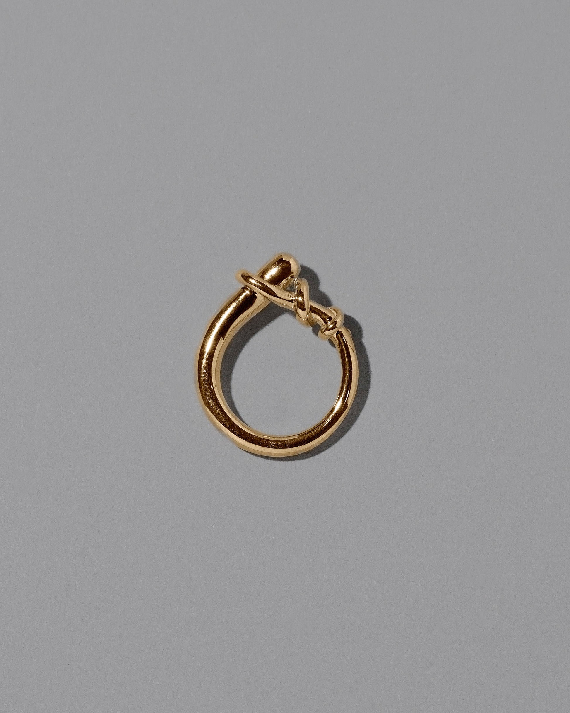 View from the side the of the CRZM 22k Gold Terrane Ring on light color background.