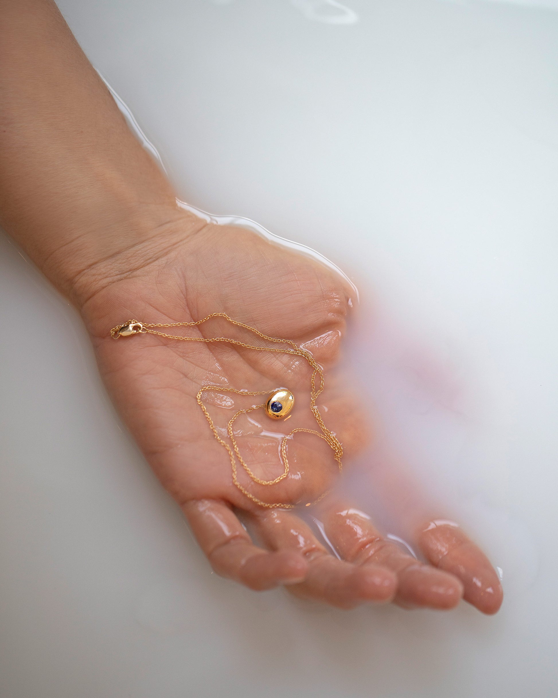 Gold Bicolor Blue Sapphire Level Stud Earrings and Yellow Gold Diamond Level Stud Earrings in hand.