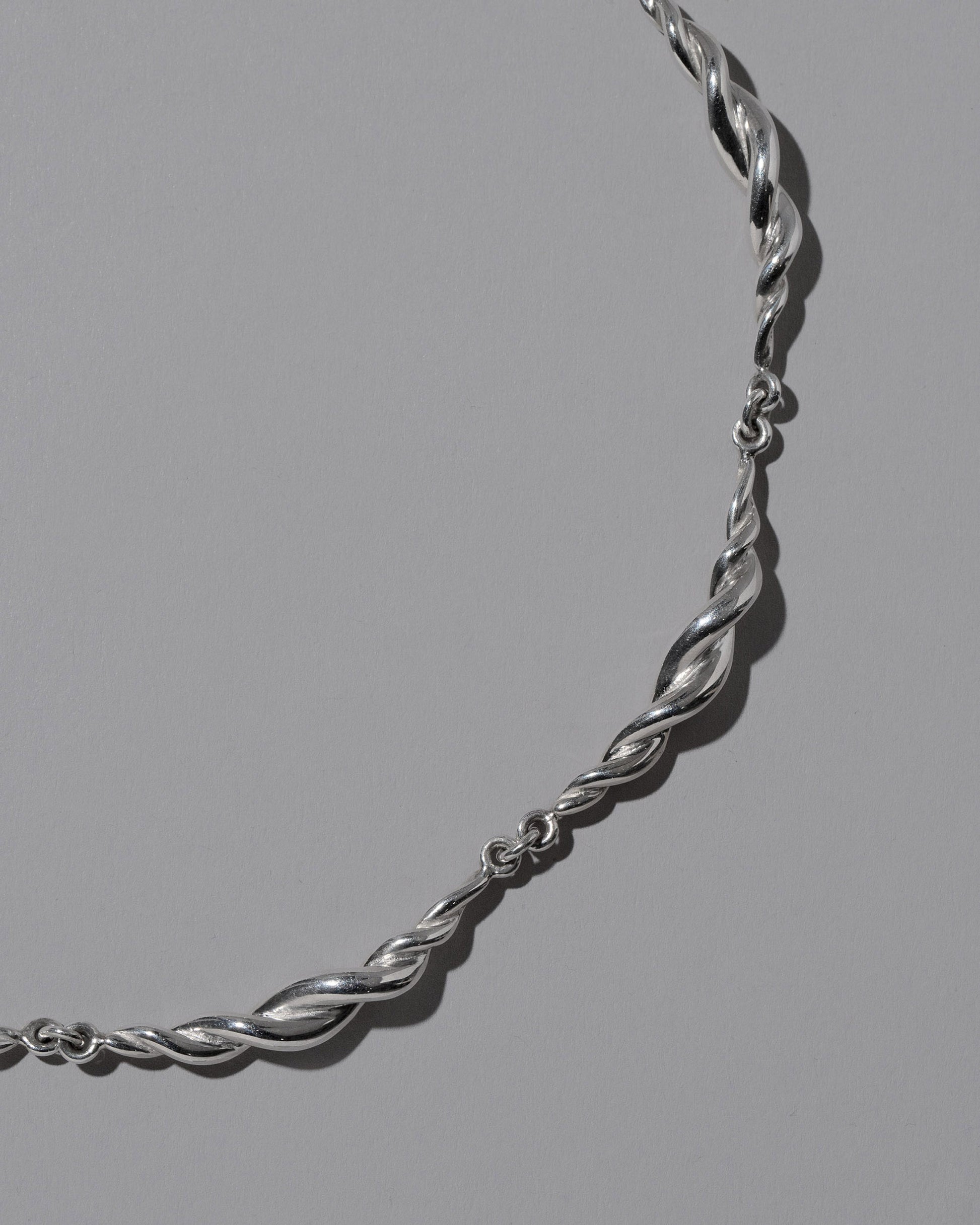 Closeup details of the CRZM Sterling Silver Foothill Necklace on light color background.