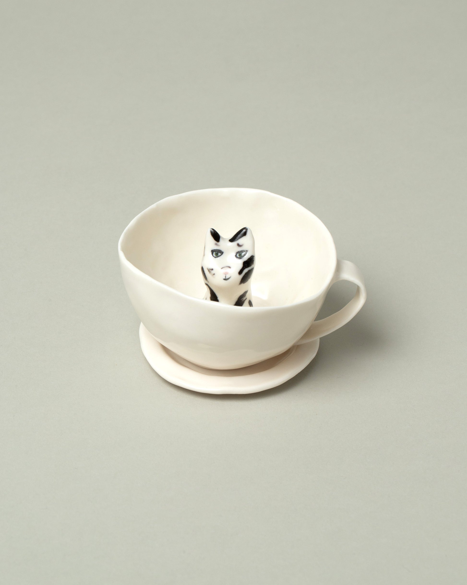 Closeup detail of the Eleonor Boström Black Spots Cat Tea Cup with Saucer on light color background.