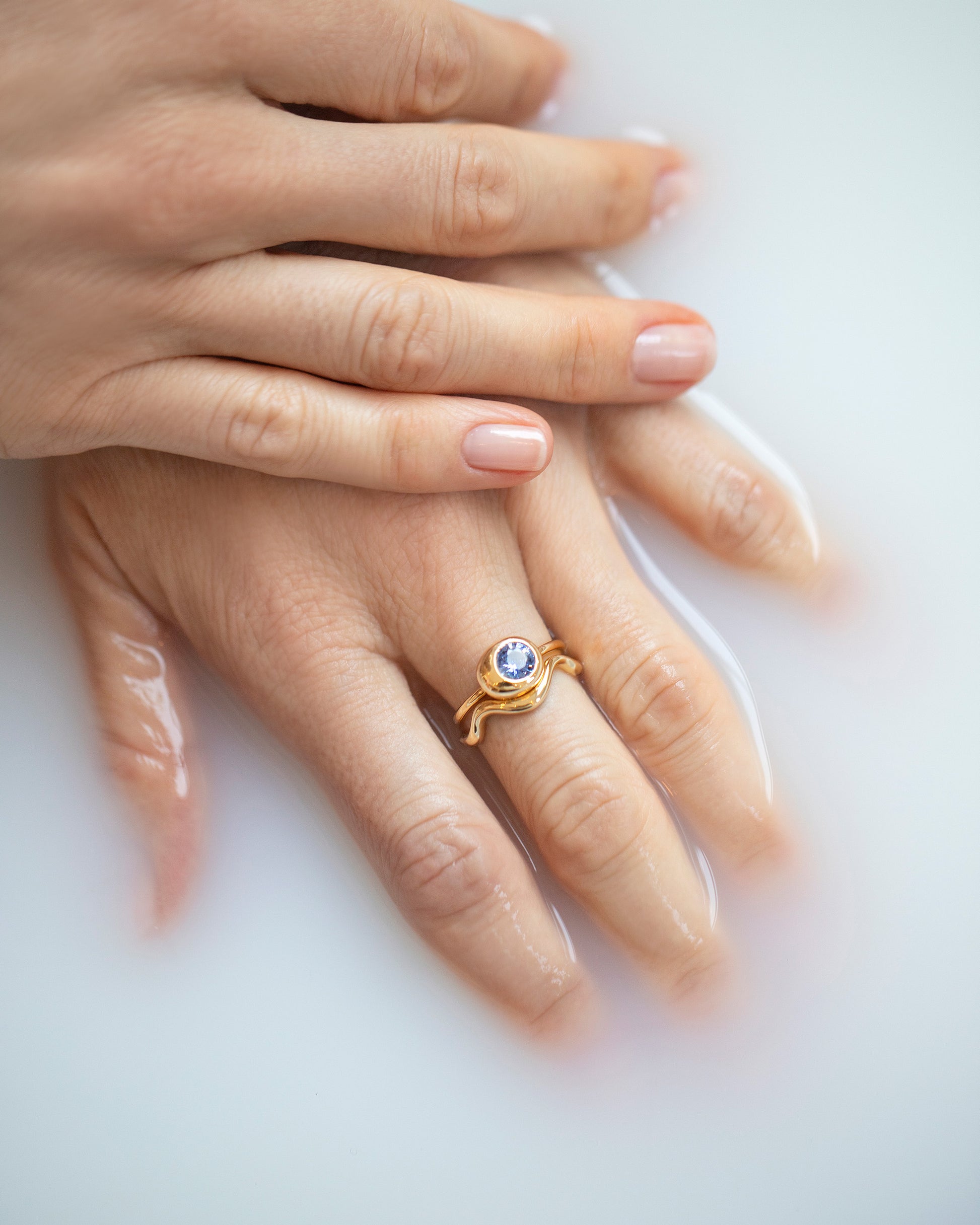 Gold Bump Band and Blue Sapphire Level Ring on model.