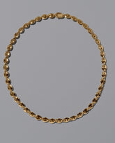 CRZM Gold Mini Bedrock Necklace on light color background.