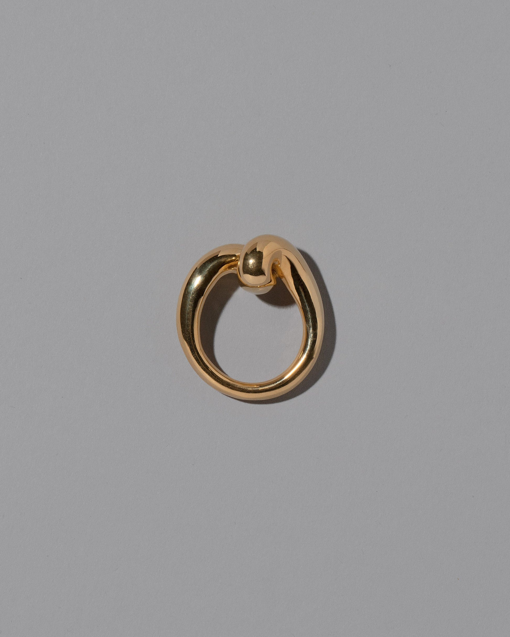 View from the side of the CRZM 22k Gold Landform Ring on light color background.