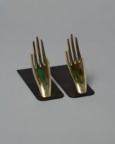 Carl Auböck Samples & Imperfects Pair of Hands Brass Bookends Set on light color background.