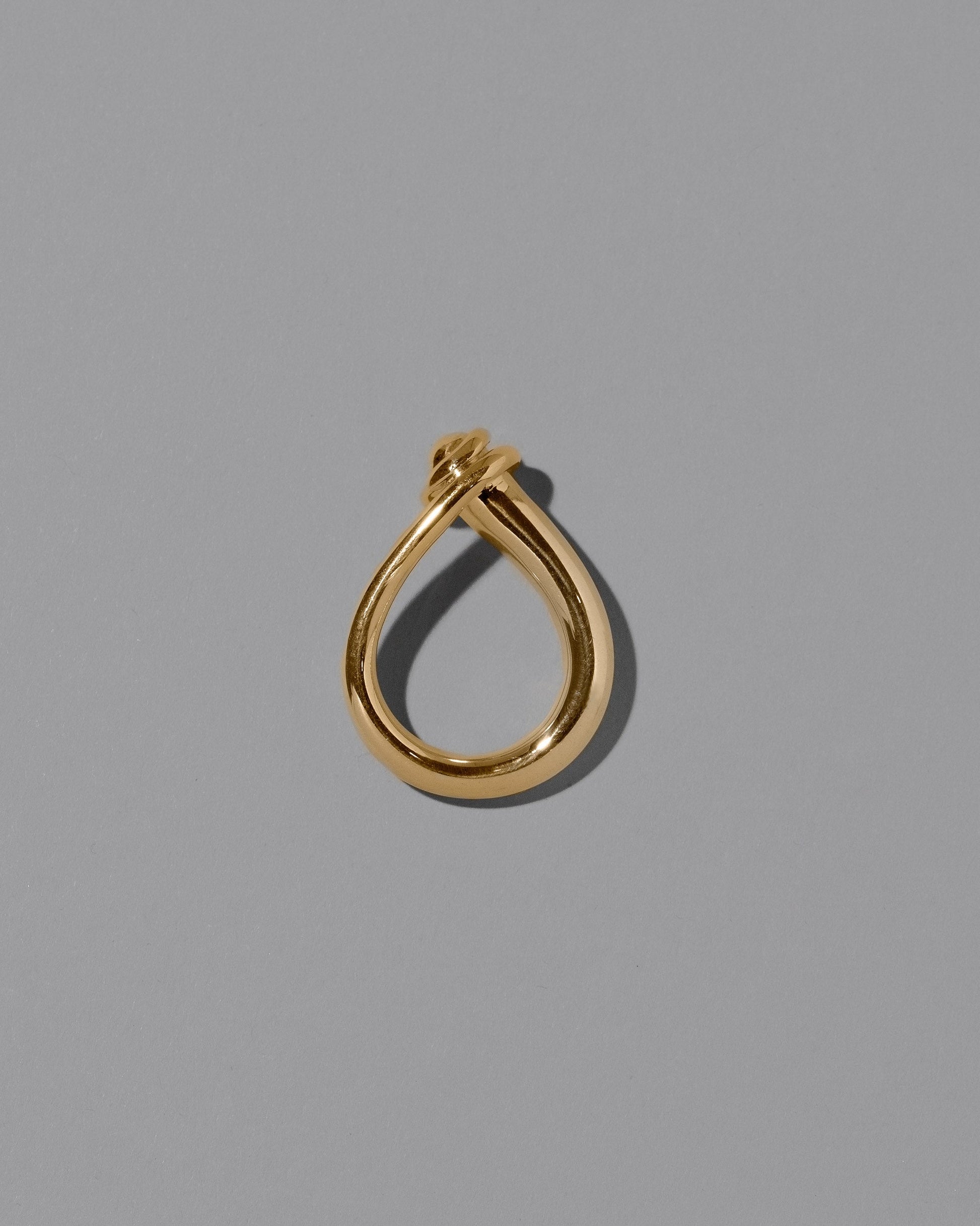 View from the side of the CRZM Gold Boulder Ring on light color background.