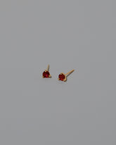 Ruby Martini Stud Earrings on light color background.