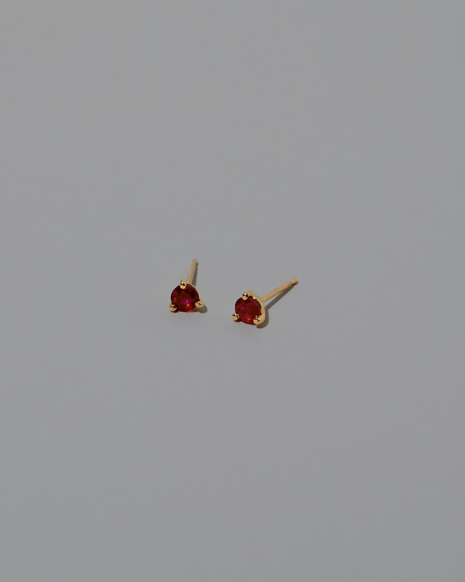 Ruby Martini Stud Earrings on light color background.