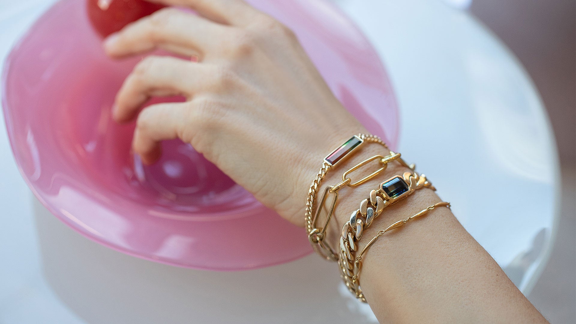 Editorial photo of model's hand and wrist wearing the Link Bracelet, Tenacity Bracelet, and Accumulation Bracelet.
