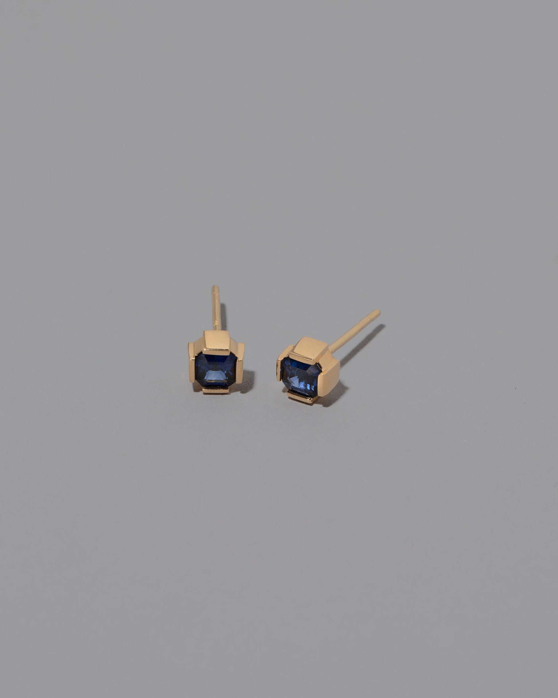 Blue Sapphire Fold Earrings on greycolor background.