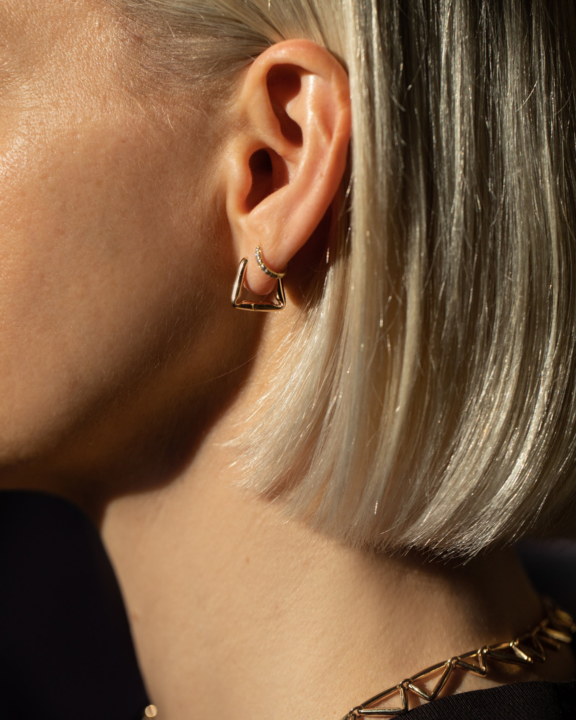 Gold Kink Hoop Earrings and Gold Flexture Necklaces on model.