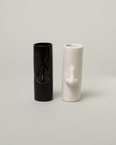 Group of Bonam Kim Black and White Nose Pillar Vases on light color background.