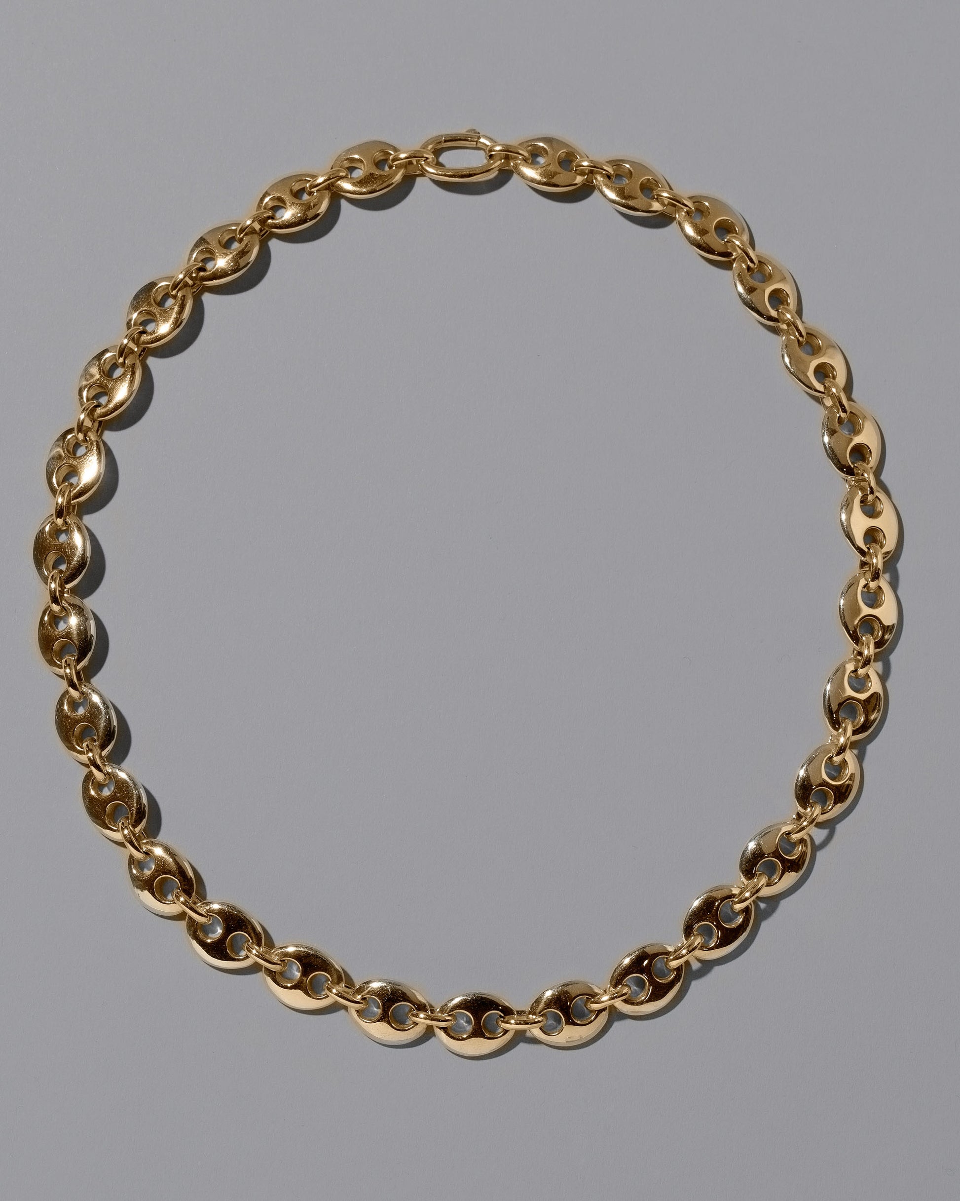 CRZM 22k Gold Bedrock Necklace on light color background.