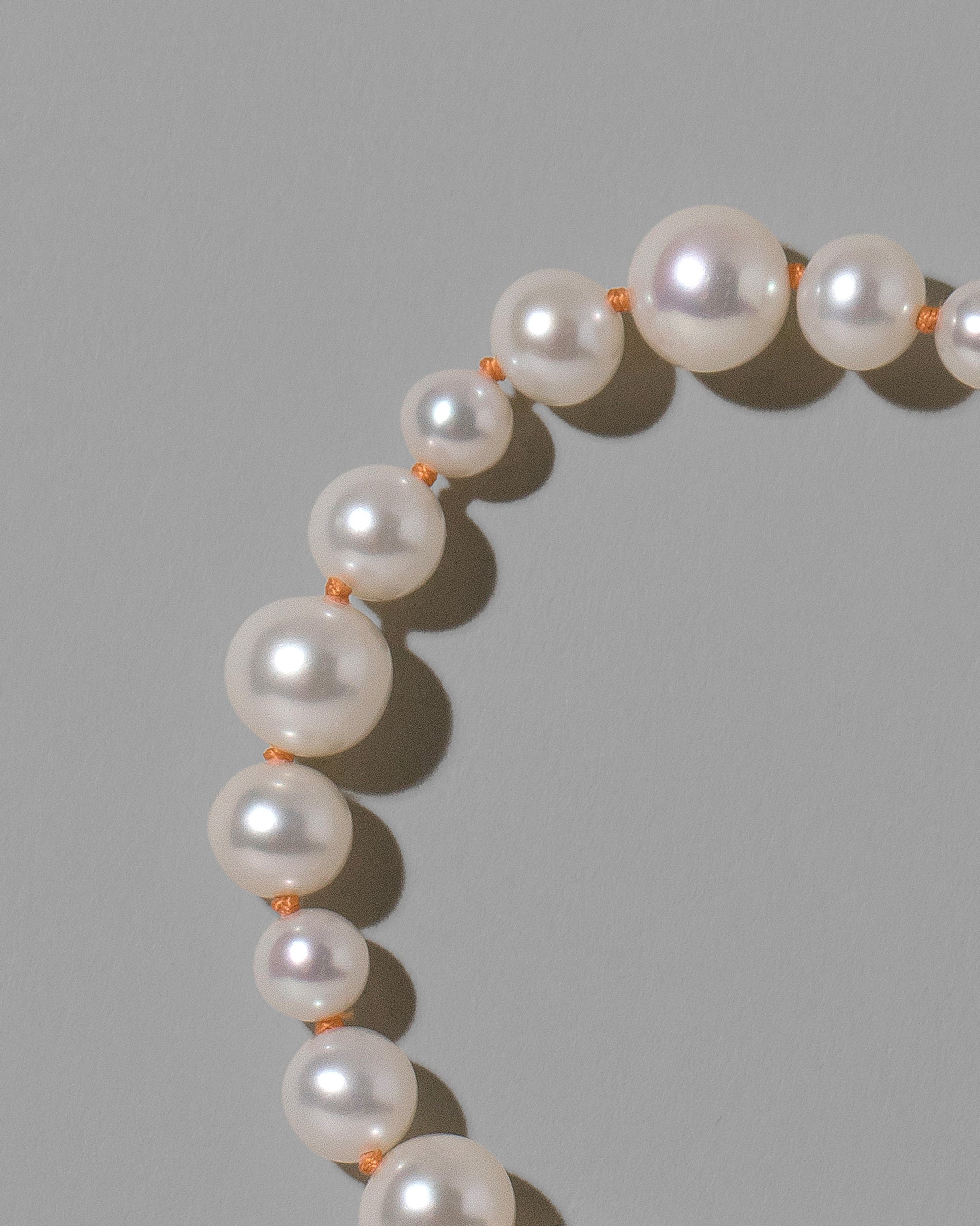 Closeup details of the Terracotta Clay Thread Bubble Pearl Necklace on light color background.