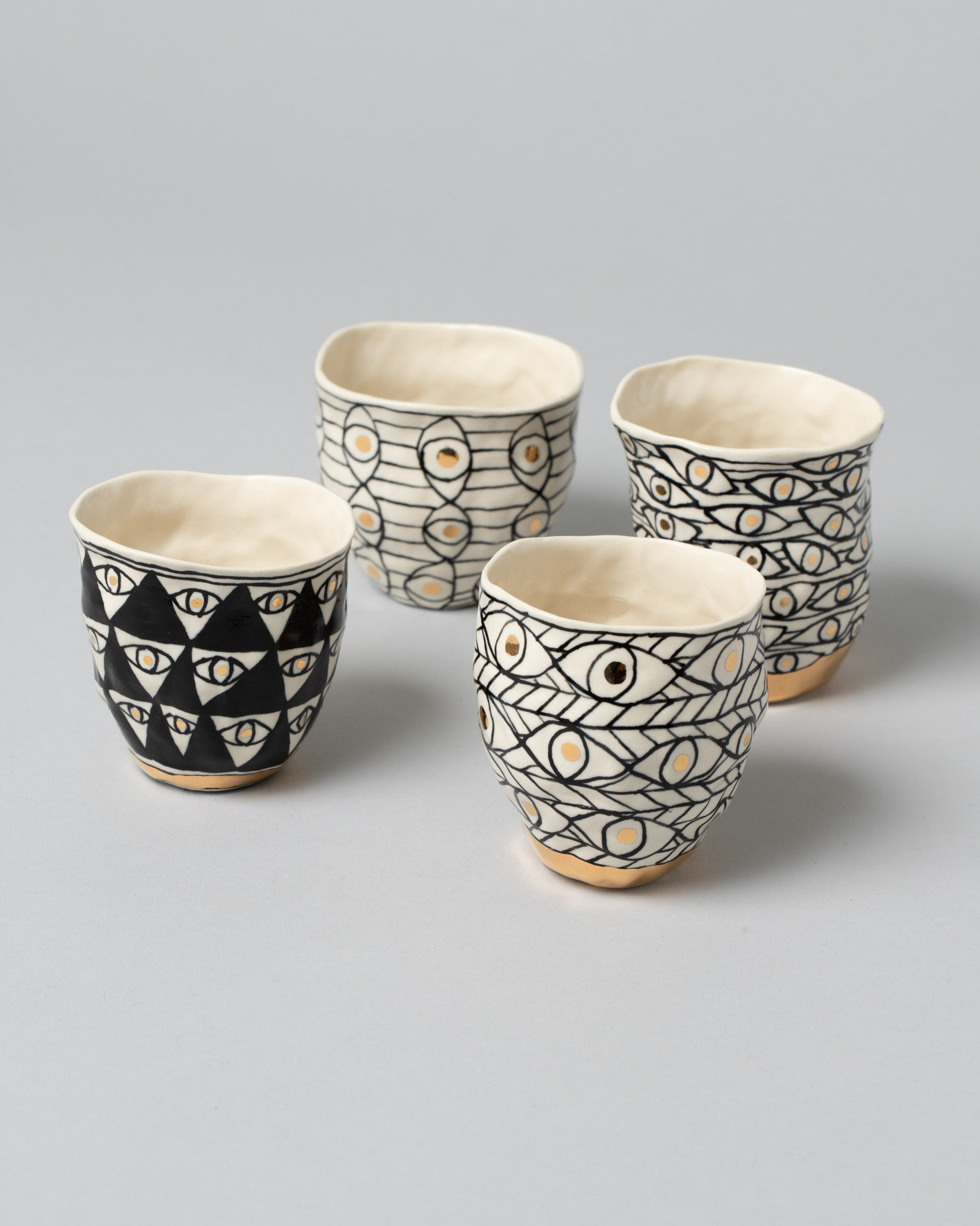 Closeup details of Suzanne Sullivan One, Three, Four and Six Eye Tumblers on light color background.