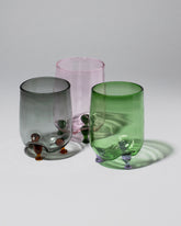 Group of Ornamental by Lameice Green & Lilac, Pink & Green and Gray & Amber Transparent Eye Candy Cocktail Glasses on light color background.