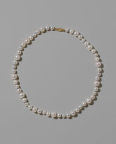 Indigo Thread Bubble Pearl Necklace on light color background.