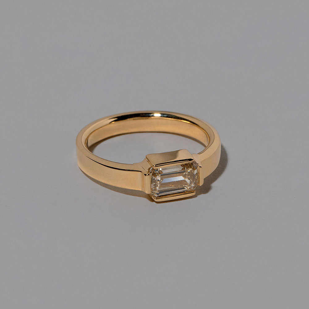 product_details::Closeup details of the Champagne Diamond Fold Ring on light color background.