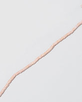 Closeup details of the Pink Peony Seed Pearl Choker on light color background.