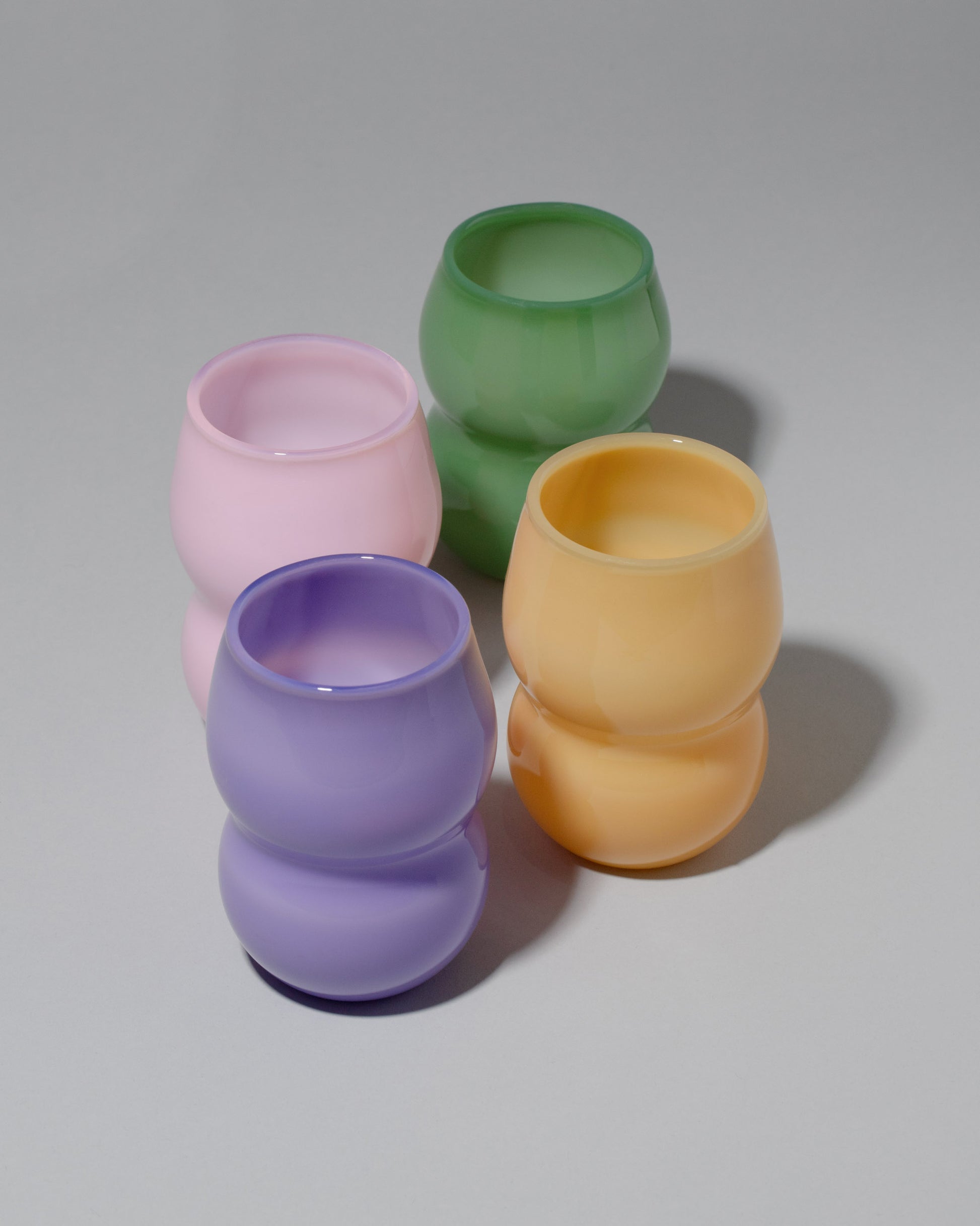 Group of Ornamental by Lameice Mint, Violet, Topaz and Pink Opaque Dreamlike Cups on light color background.