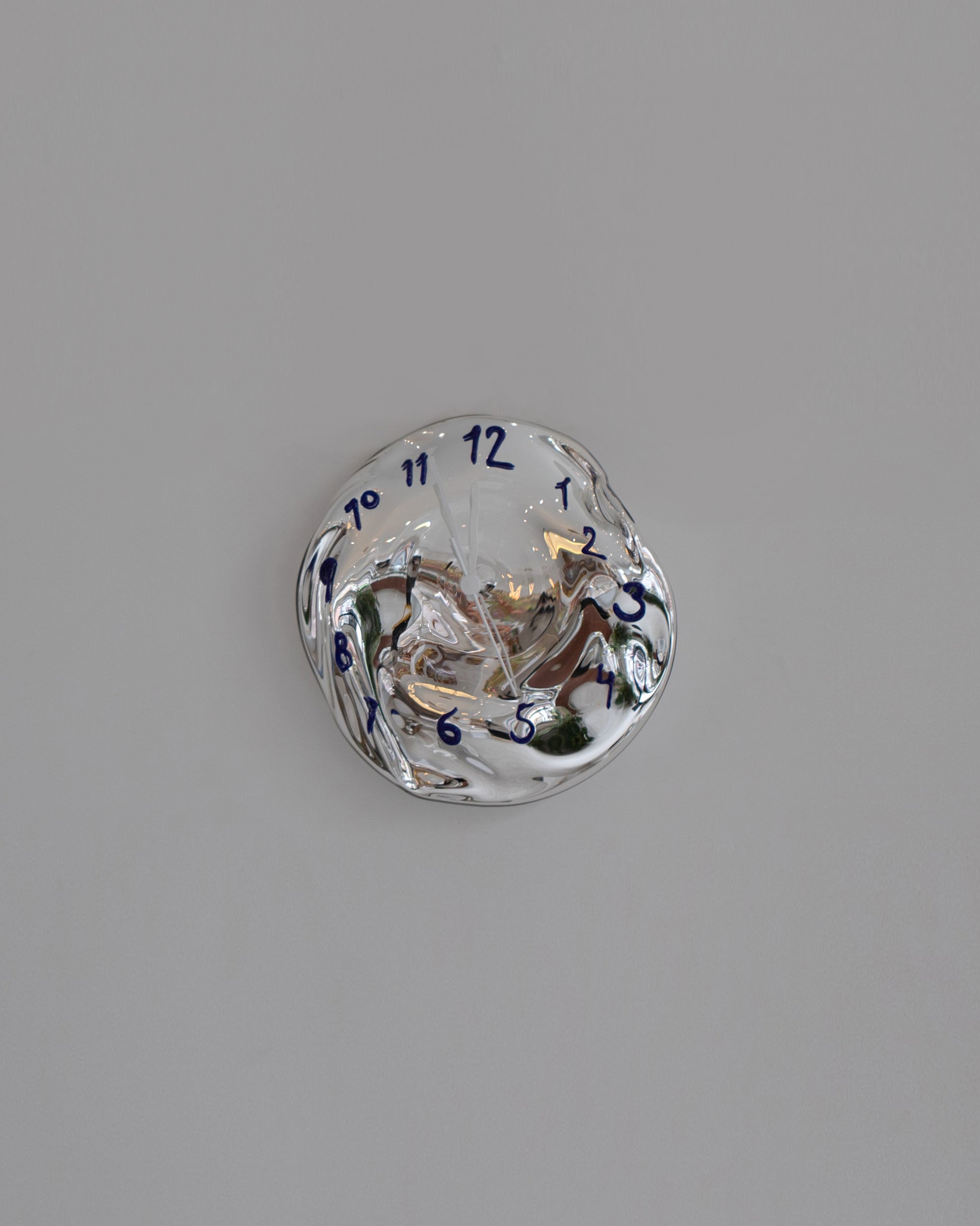 Silje Lindrup White Hands Two Blue Glass Wall Clock on light color background.