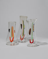 Group of FACEVESSEL Clear Mega Face Vases on light color background.