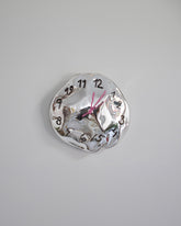 Silje Lindrup Pink Hands Two Black Glass Wall Clock on light color background.