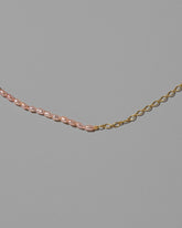 Closeup details of the Half Oval Chain & Peony Seed Pearl Necklace on light color background.