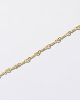 Closeup detail of the Twisted Chain Necklace on light color background.