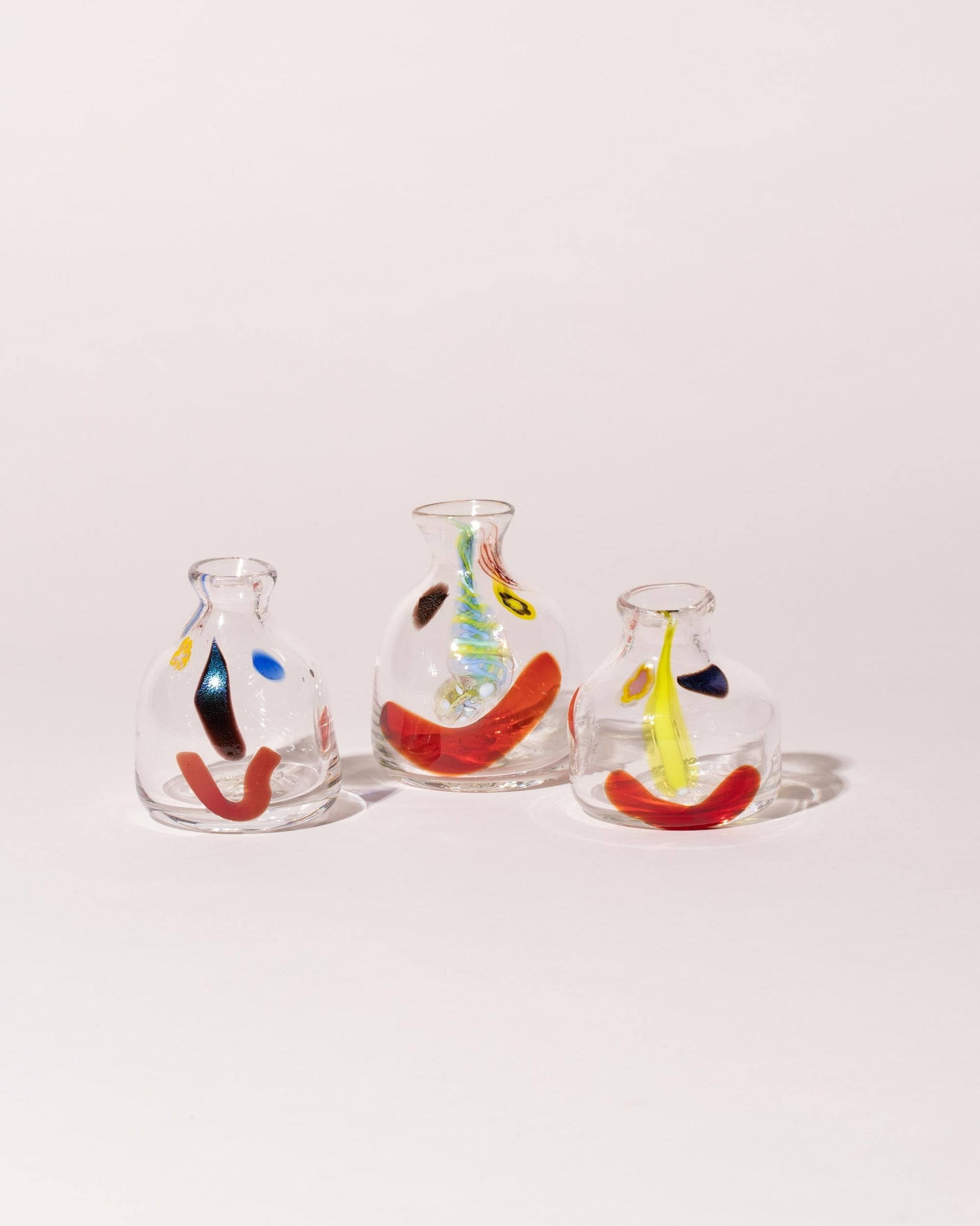 Group of FACEVESSEL Small Bud Vases on light color background.