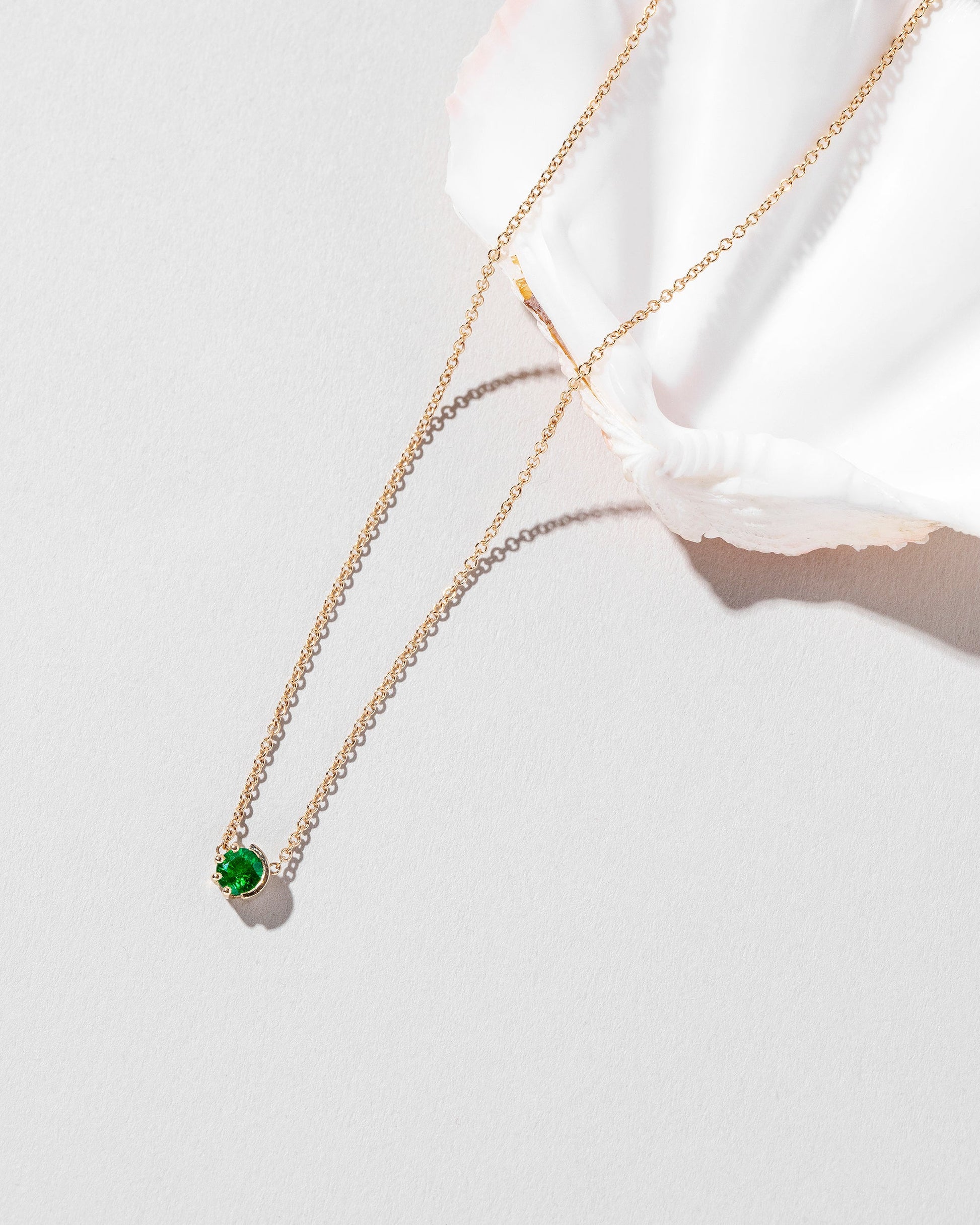 Styled image of the Emerald Sun & Moon Necklace.