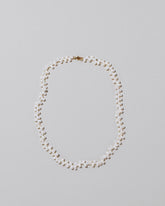 Small Zipper Pearl Necklace on light color background.
