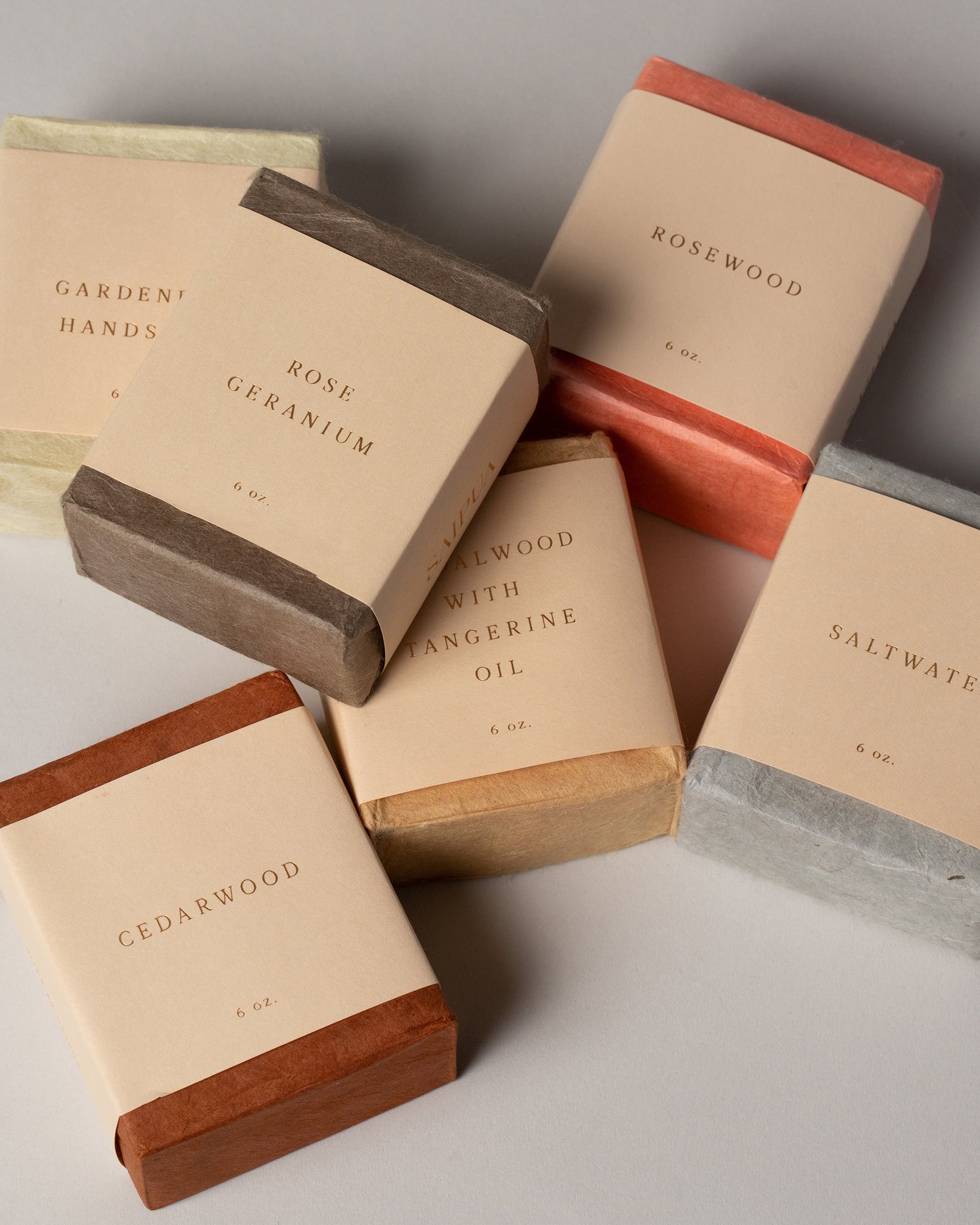 Styled image featuring the Saipua Gardenia, Rose Geranium, Rosewood, Sandalwood with Tangerine Oil, Saltwater and Cedarwood Soaps.
