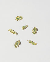 Group of Arugula Charms on light color background.