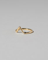 View from the side of the Gold White Diamond Three Stone Triangle Band on light color background.