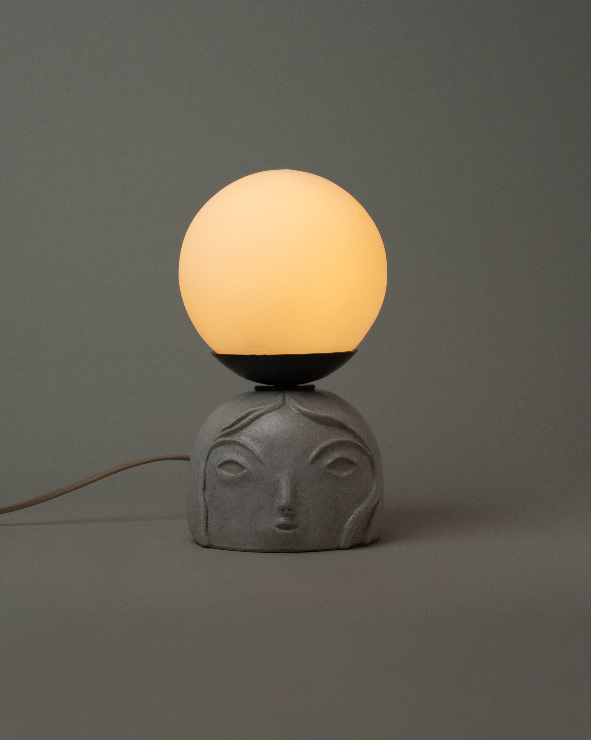 Detail view of Rami Kim Small / White Floating Penelope Table Lamp on light color background with lamp on.