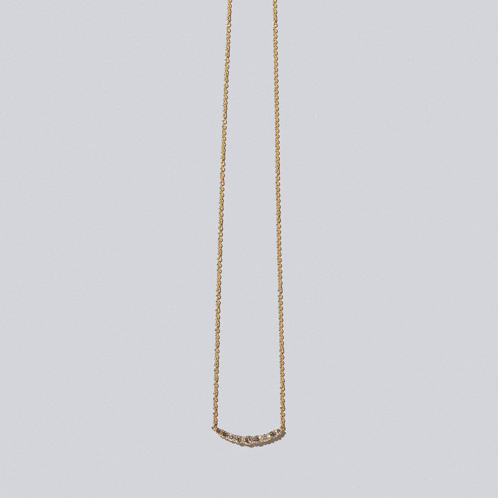 product_details::Champagne Diamond Crescent Necklace on light color background.