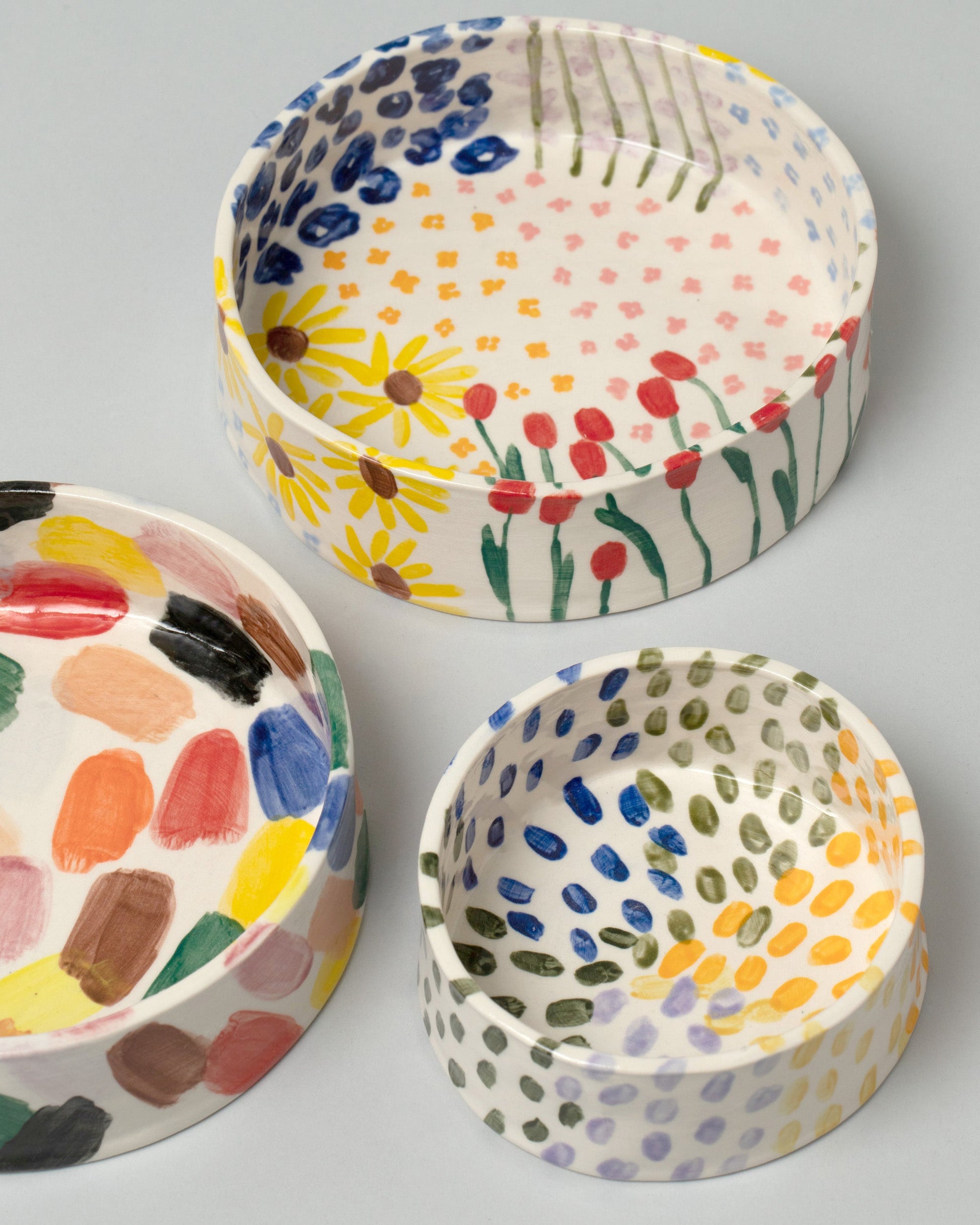 Closeup details of a group of Amanda Lucia Côté Small and Large Bowls on light color background.