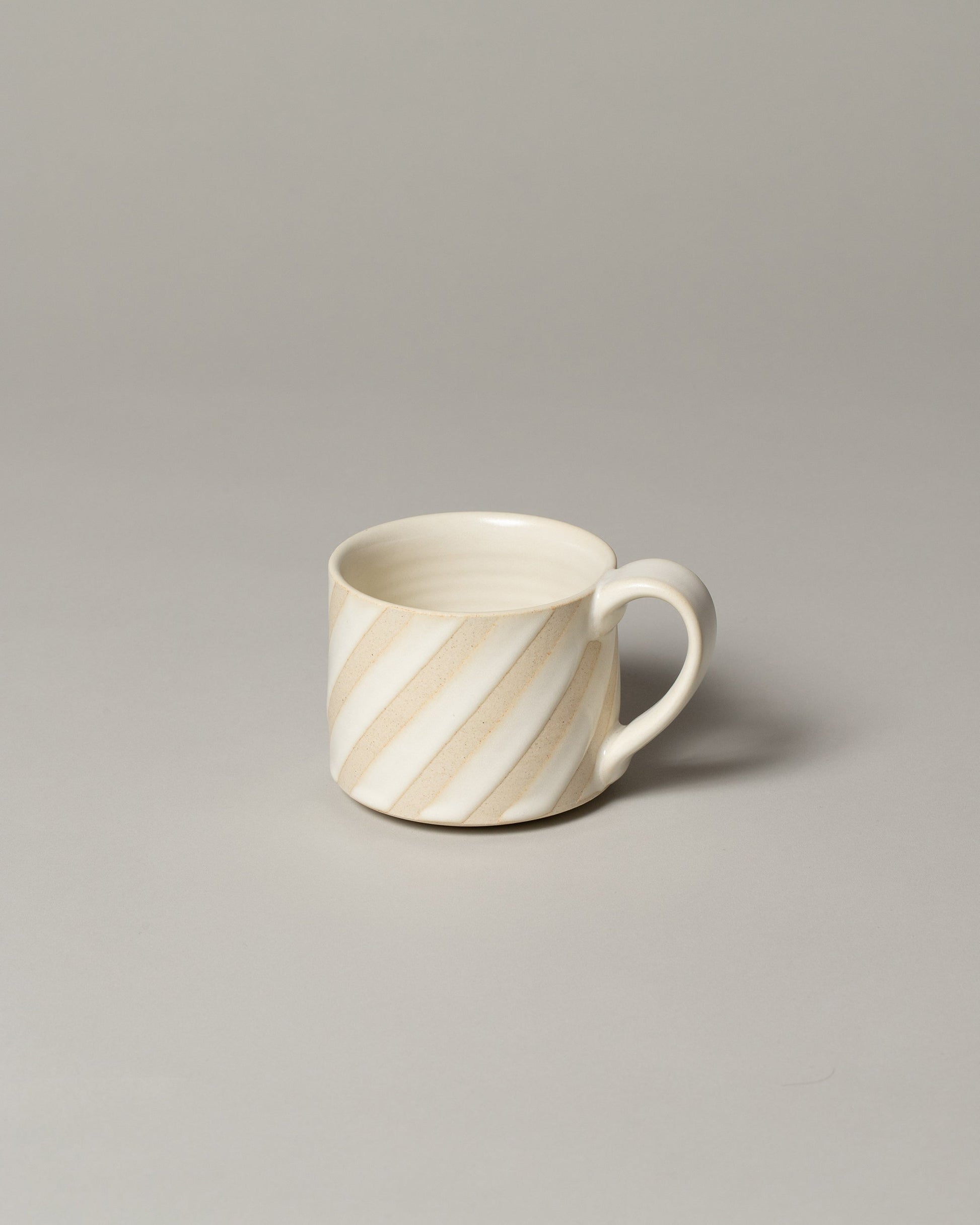 Jeremy Ayers White Diagonal Striped Mug on light color background.