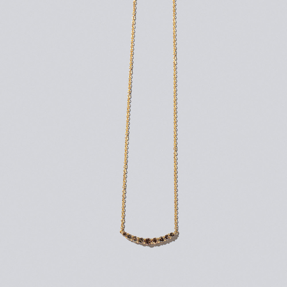 product_details::Cognac Diamond Crescent Necklace on light color background.