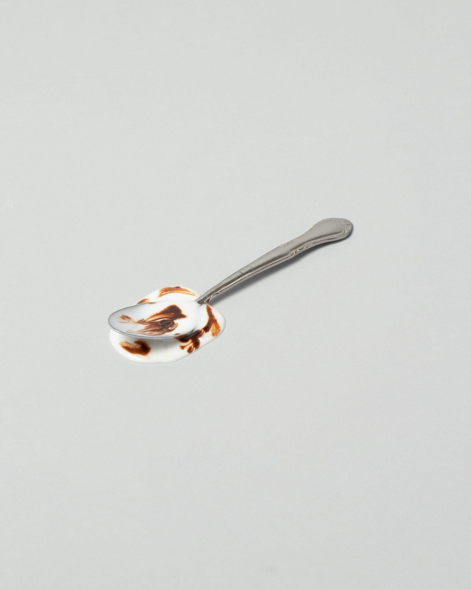 Spills Ice Cream Spoon on light color background.