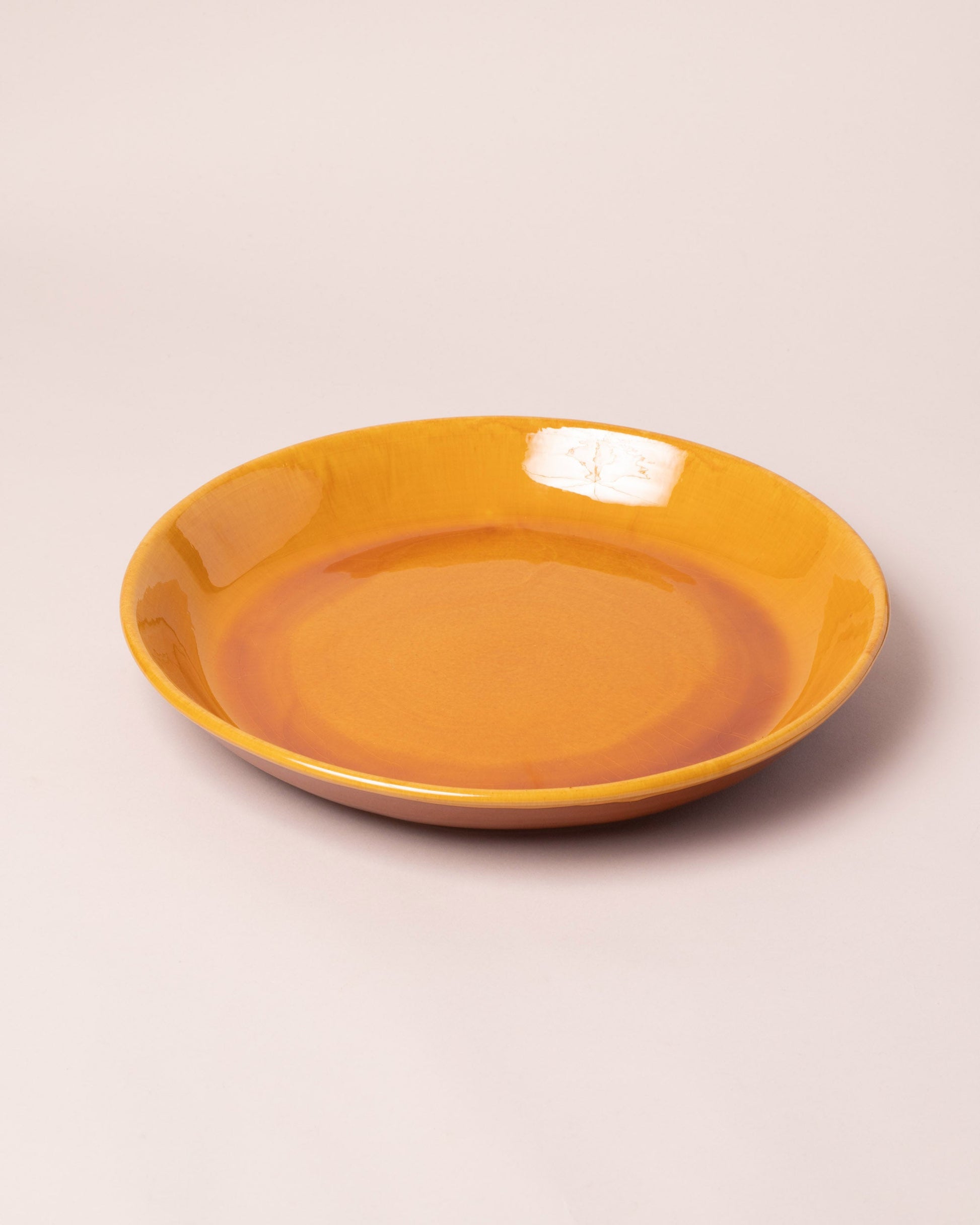 La Ceramica Vincenzo Del Monaco Caramel Yellow Circular Serving Dish on light color background.