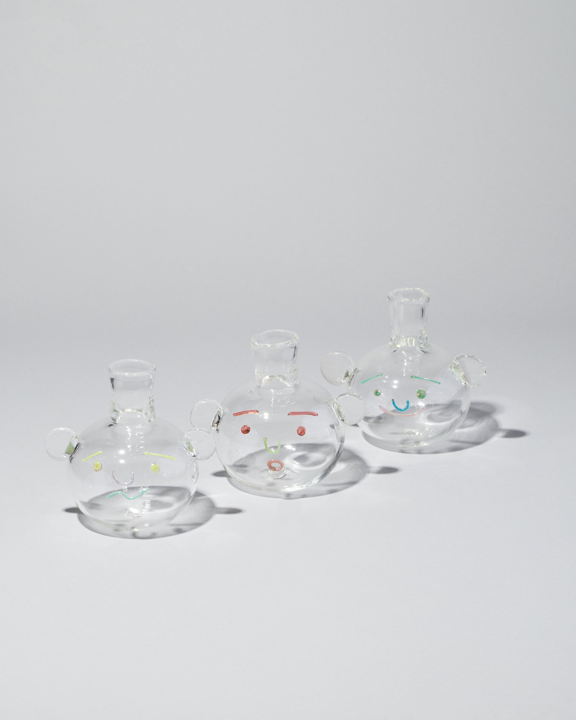 Group of TAK TAK Goods Salty, Surprised and Smiley Bubble Vases on light color background.