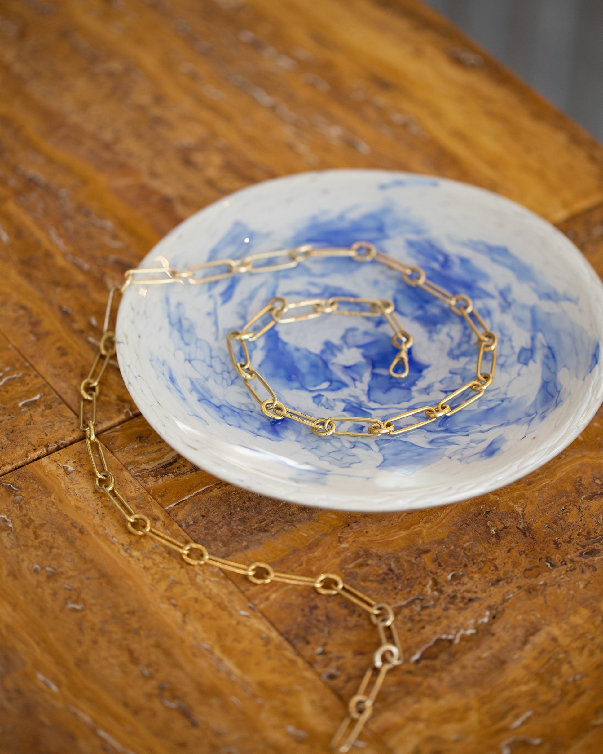 Styled image featuring Stories of Italy Blue and Endless 34" Link Necklace and Nougat Dessert Plates.