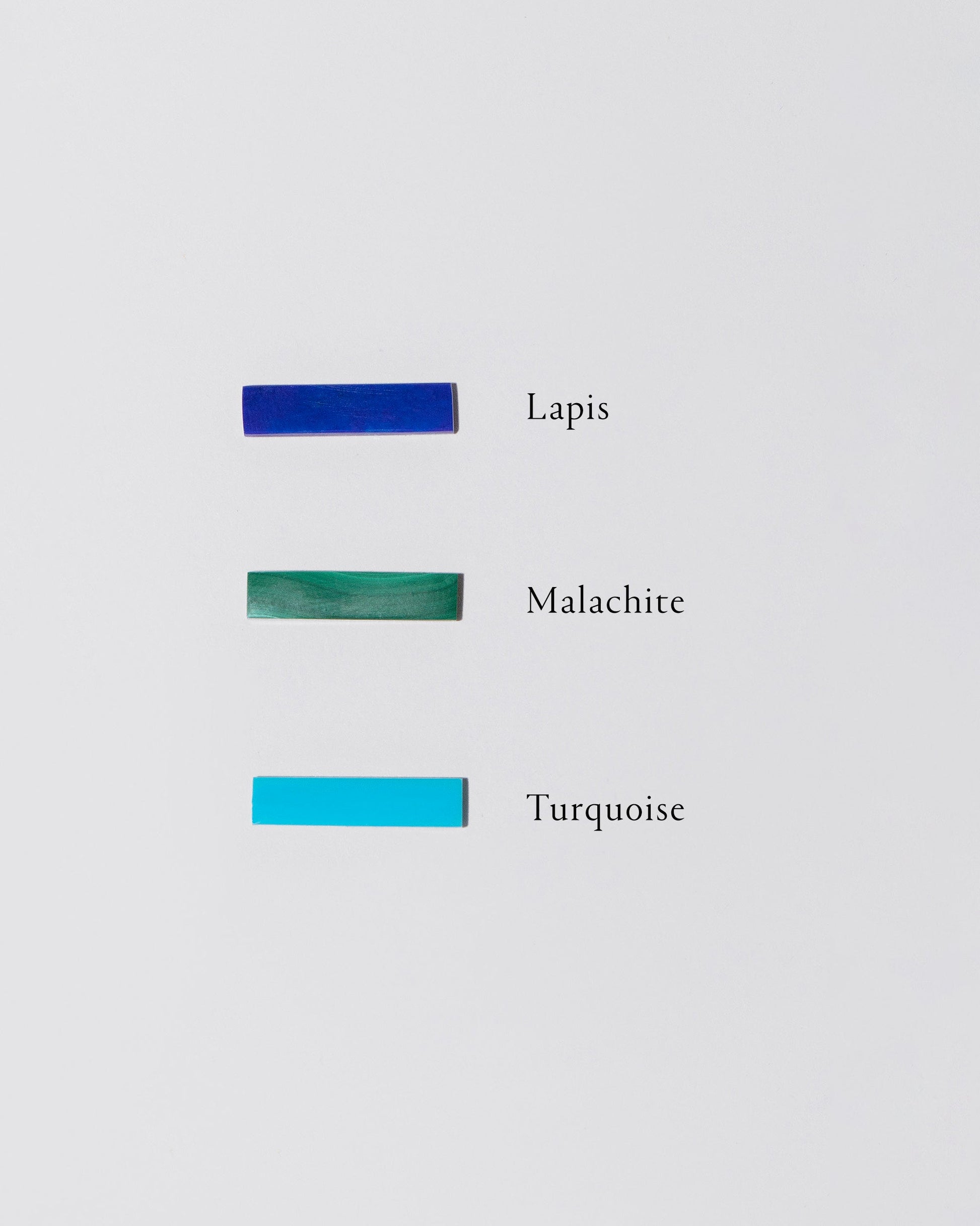 Specimens of lapis, malachite and turquoise on light colored background.