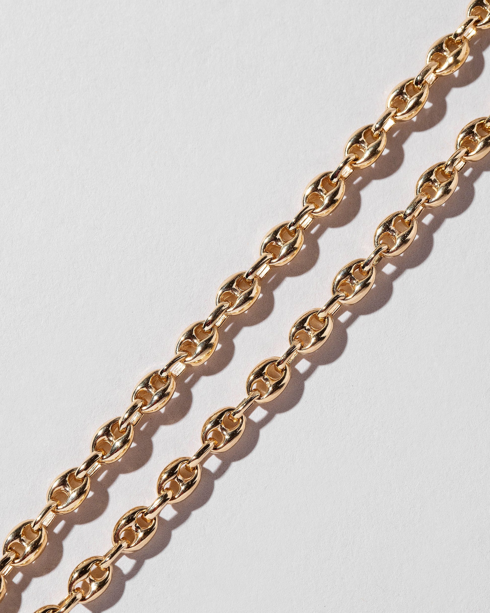 Closeup details of the Segmented Chain Necklaces on light color background.