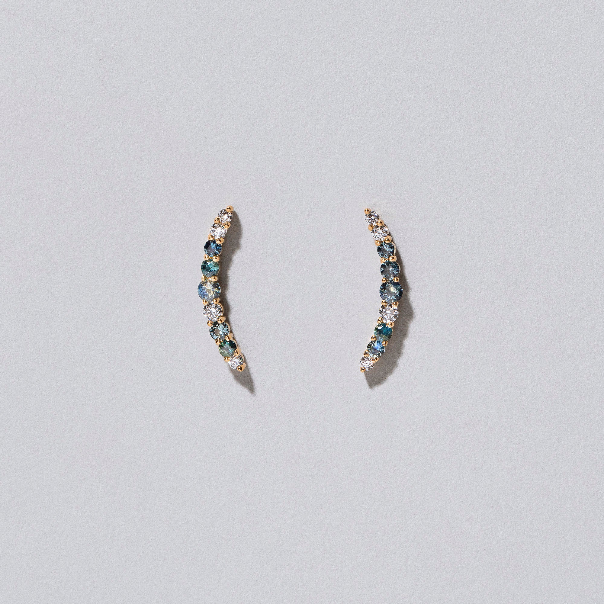 product_details::Crescent Ear Climber Stud Earrings - Sapphier and White Diamond on light colored background.