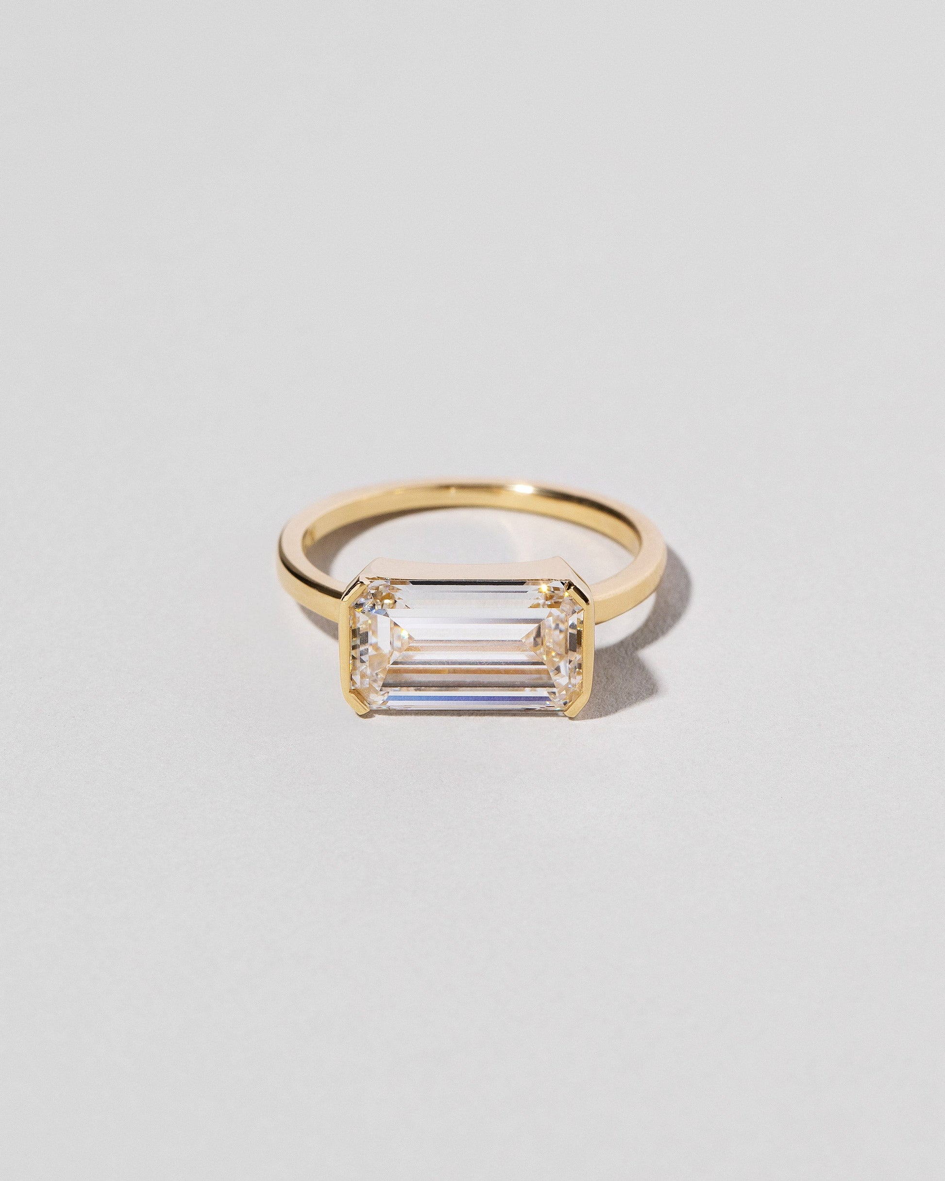  Emerald Cut Diamond Solitaire Ring on light color background.